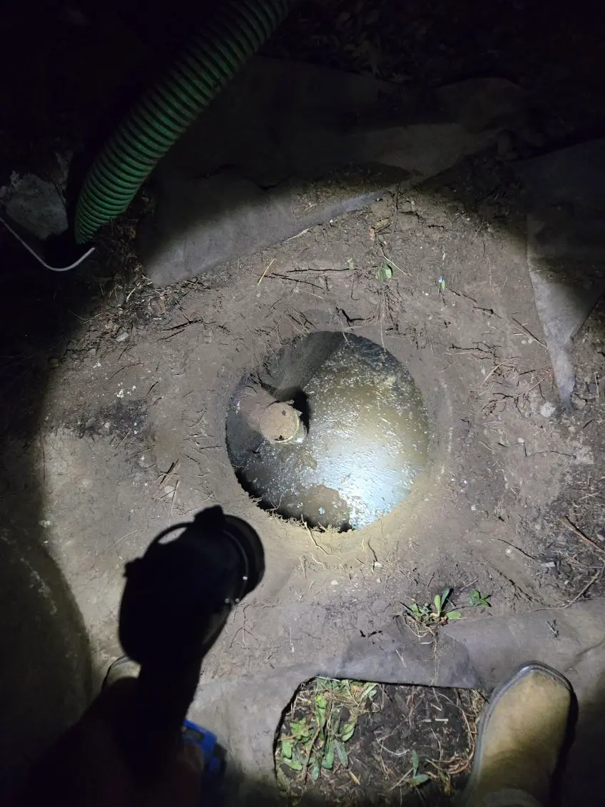 Septic Pros crew pumping a septic tank after dark on an after-hours emergency call