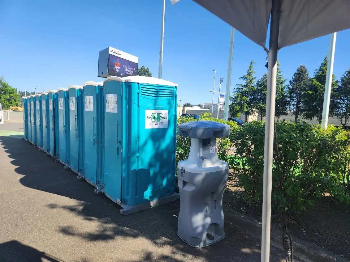 Septic Pros portable restrooms and handwashing stations lined up under a tent at an event