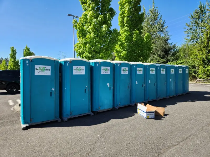 A row of Septic Pros portable toilets and handwashing stations ready for delivery